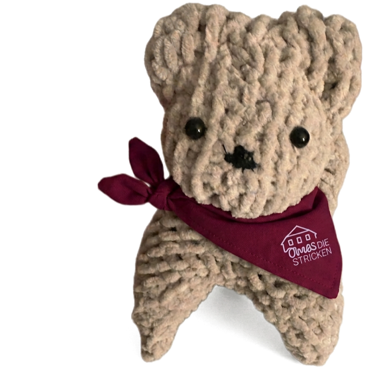 Finished knitted bear with a red scarf