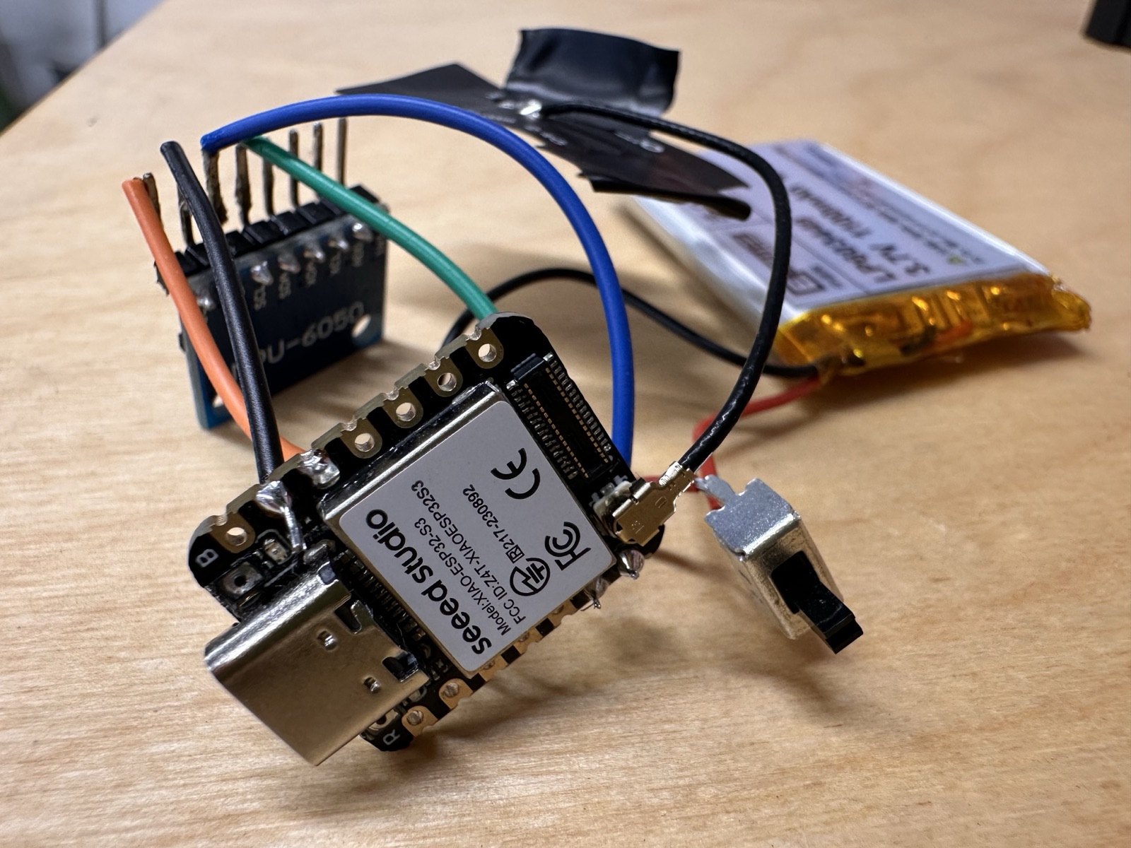 The assembled electronics: MPU-6050 motion sensor, XIAO ESP32-S3 board, rechargeable LiPo battery and power switch wired together
