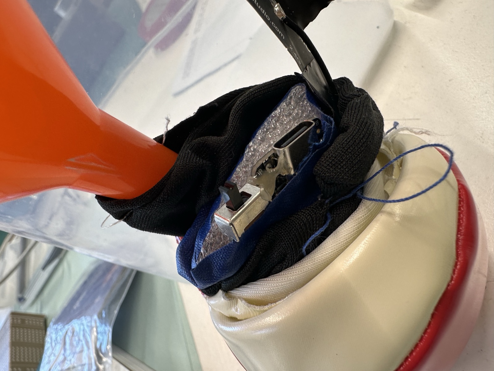 The padded electronics being sewn into the opening of a juggling ball