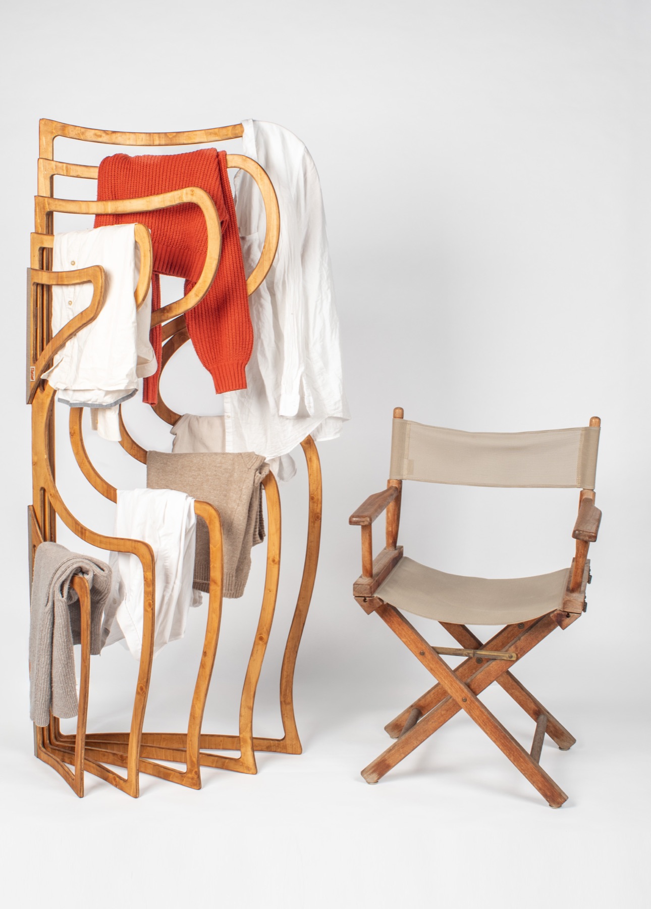 The final Relief prototype in birch plywood, holding folded clothes, next to a director's chair for scale