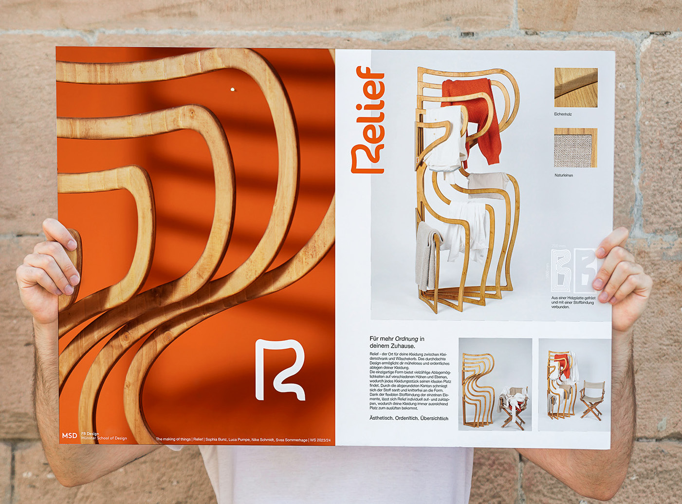 A person holding up the printed Relief poster against a brick wall, showing the product shot, material swatches, and project credits